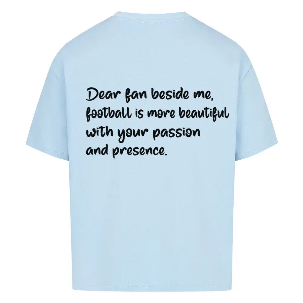 Football Oversized Shirt: Hellblaues Oversized-T-Shirt mit schwarzem Rückendruck: „Dear fan beside me, football is more beautiful with your passion and presence.“