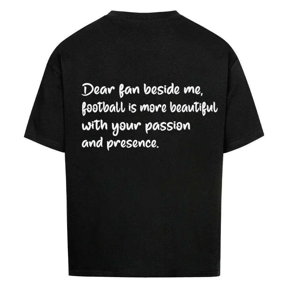 Football Oversized Shirt: Schwarzes Oversized-T-Shirt mit weißem Rückendruck: „Dear fan beside me, football is more beautiful with your passion and presence.“