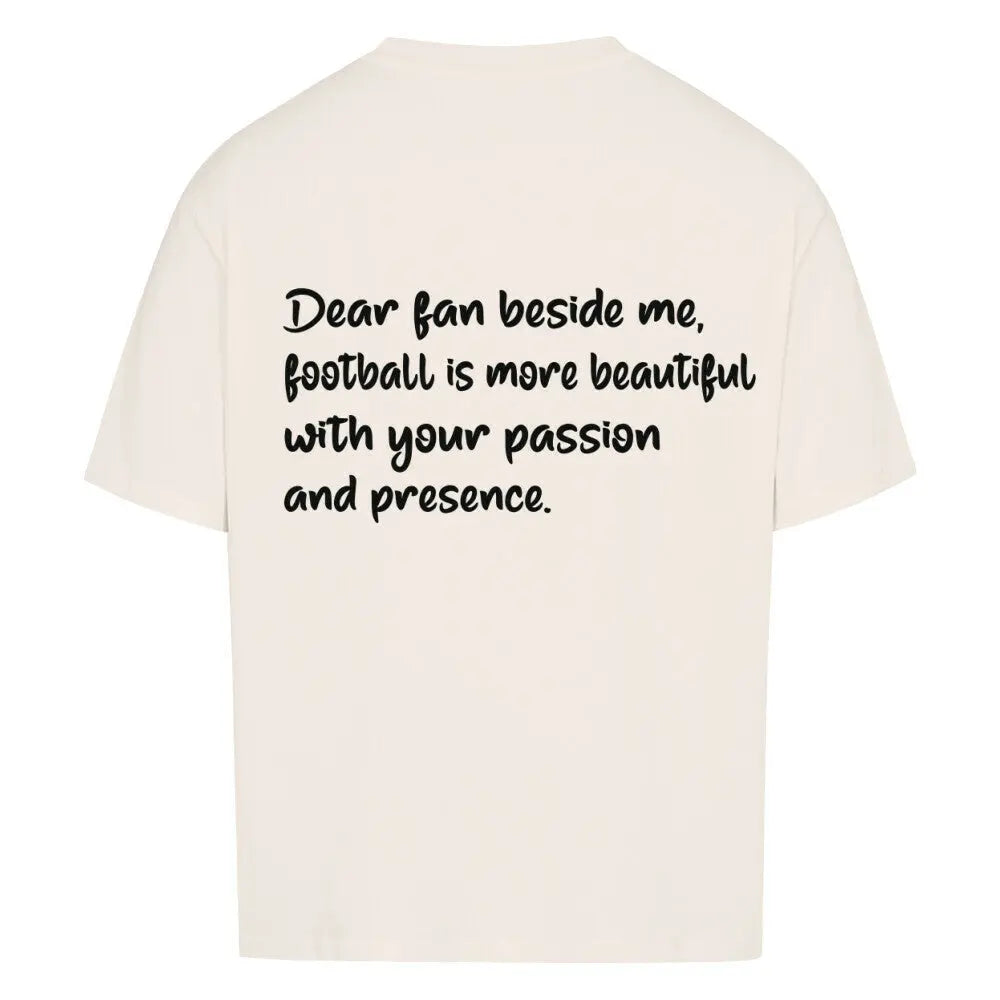 Football Oversized Shirt: Beiges Oversized-T-Shirt mit großem schwarzen Rückendruck: „Dear fan beside me, football is more beautiful with your passion and presence.“