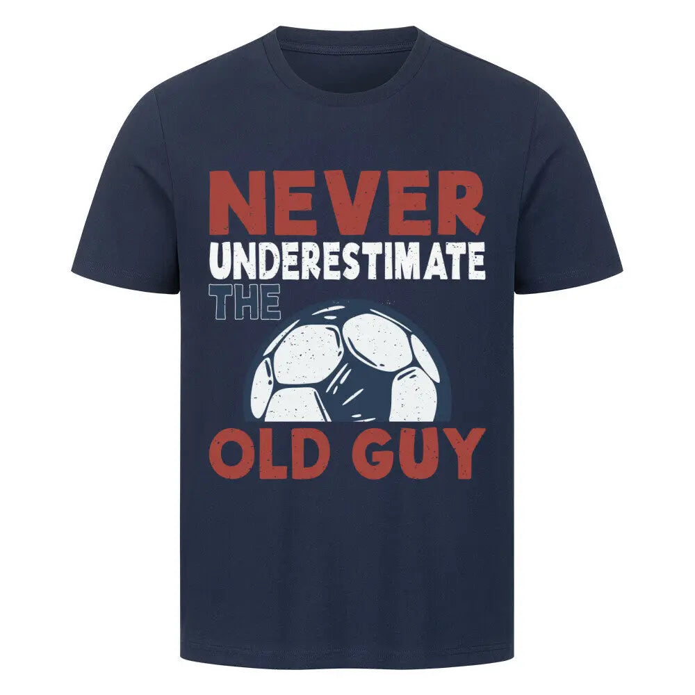 Premium T-shirts Never Underestimate the Old Guy: Dunkelblaues T-Shirt mit farbigem Schriftzug „Never underestimate the old guy“ und stilisiertem Fußball auf der Brust 